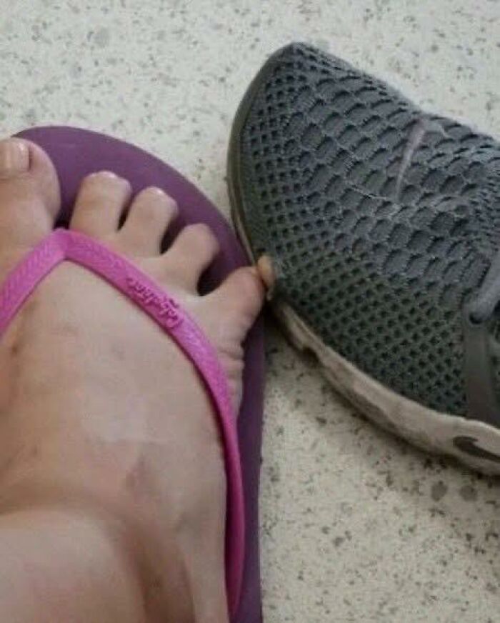 Close-up of foot with unusual toe placement between a pink flip-flop and a gray sneaker, highlighting pleasures of the occult humor.