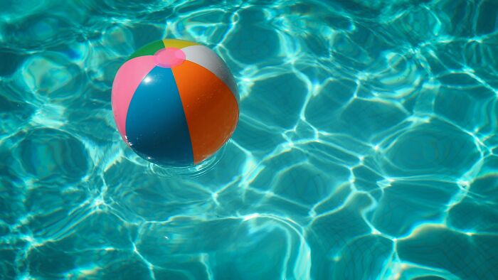 Colorful beach ball floating on clear water reflecting light, illustrating moments related to near-death experiences.