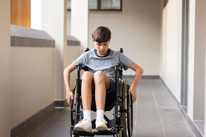 Boy in a wheelchair navigating a hallway, representing disabled child in a babysitting and family care situation. Boy in a wheelchair navigating a hallway, representing disabled child in a babysitting and family care situation.