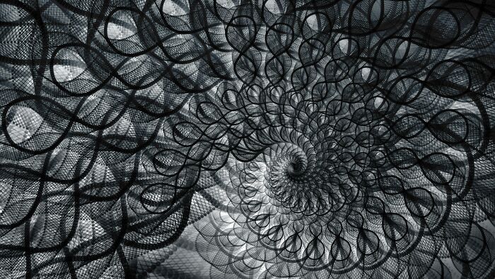 Abstract black and white spiral pattern with layered mesh textures illustrating infinite luck or happiness concept.