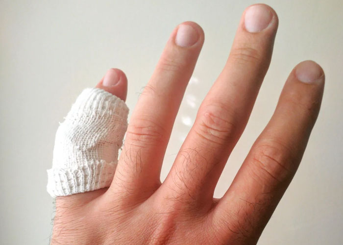 Hand with bandaged finger showing an injury, illustrating ridiculous reasons that ended up in the emergency room.