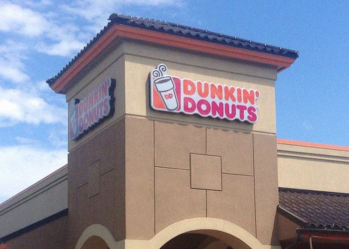 Dunkin Donuts storefront under blue sky highlighting ridiculous reasons people ended up in emergency room.