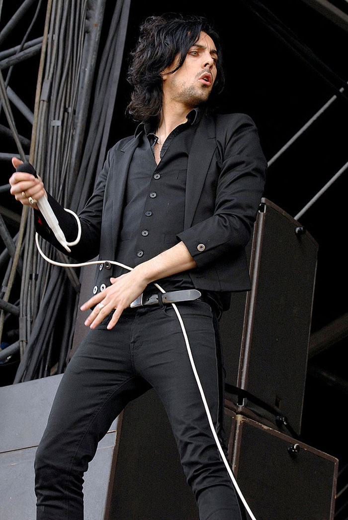 Rock star performing on stage with microphone, related to prison attack and crimes against children case.