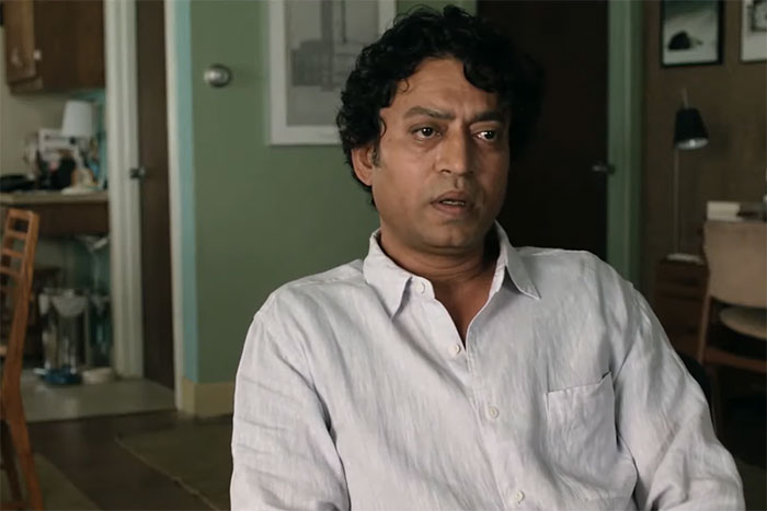 Man in a white shirt sitting indoors, conveying emotion, related to lines from movies that tug at the heartstrings.