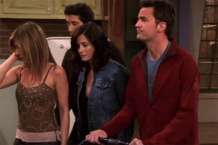 Four friends from a popular TV show standing in a kitchen, capturing iconic lines from movies that tug at heartstrings.