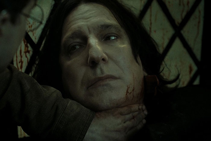 A close-up of a man showing deep emotion with bloodstains, illustrating powerful lines from movies that tug at heartstrings.