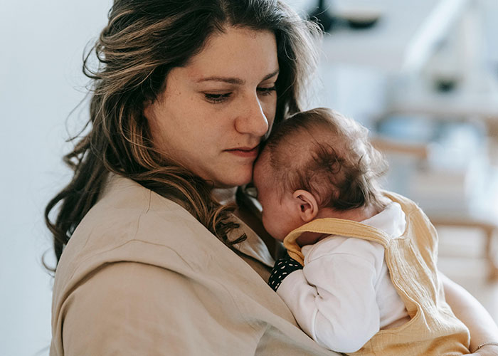 Woman holding a baby closely, reflecting on a serious situation involving illegal baby adoption and CPS intervention. Woman holding a baby closely, reflecting on a serious situation involving illegal baby adoption and CPS intervention.