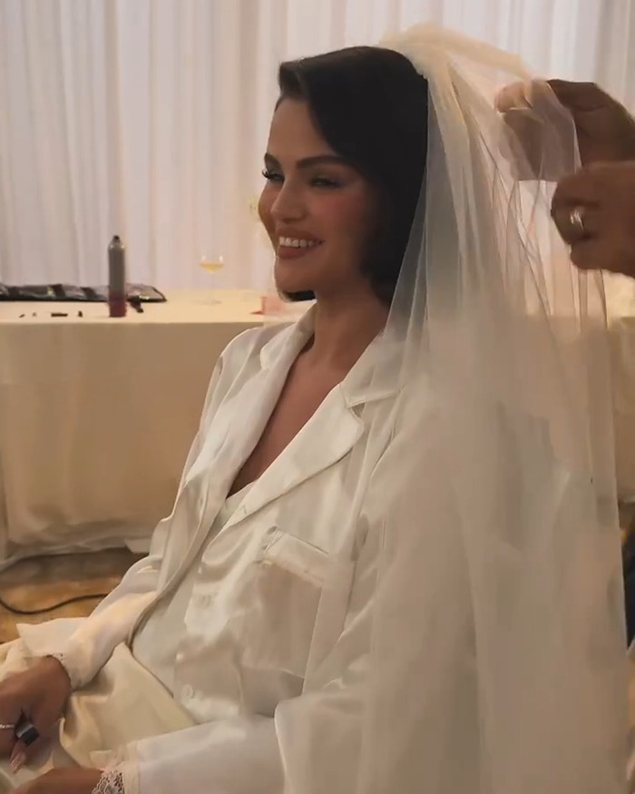 Selena Gomez smiling while getting a wedding veil adjusted, related to kidney donation controversy and wedding invite issues.
