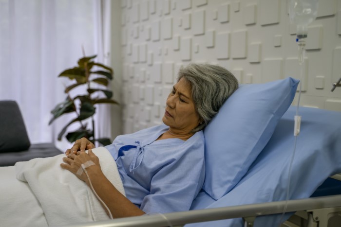 Elderly woman in hospital bed looking unwell, relating to parents lied food allergies daughter no contact situation.