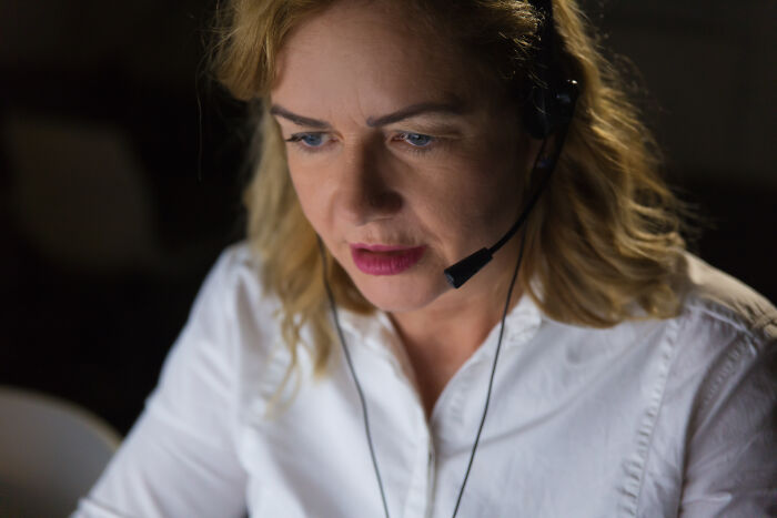 911 operator wearing headset, focused on strange calls that turned out to be true during a night shift.