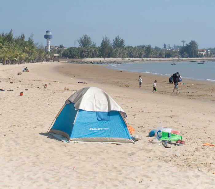 Baby left alone on a beach near a small tent with scattered toys, highlighting concerns about child safety and neglect. Baby left alone on a beach near a small tent with scattered toys, highlighting concerns about child safety and neglect.