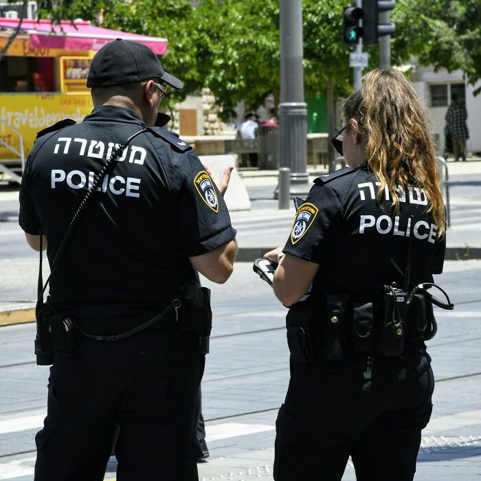 Two police officers standing outdoors, highlighting subtle sexism and gender bias issues in professional roles.
