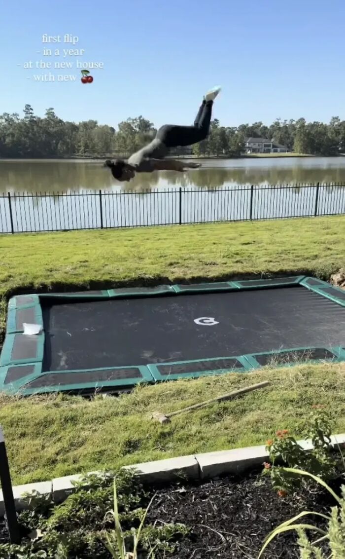 Simone Biles performing a flip on a backyard trampoline near a lake during a sunny day sparking plastic surgery rumors.