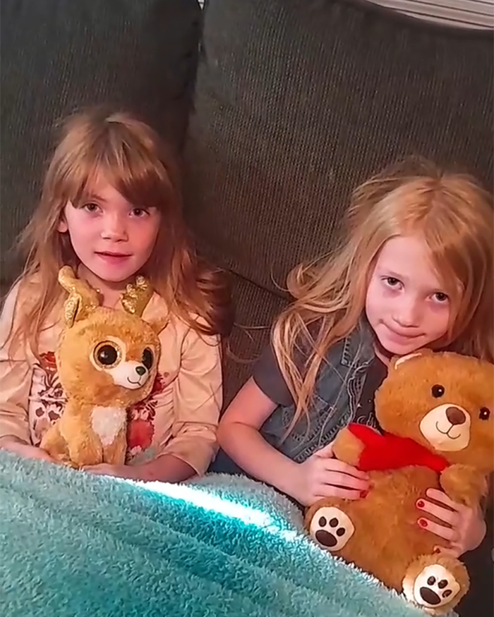 Two little sisters sitting on a couch holding stuffed animals, a heartmelting gesture by hospital for surgery support.