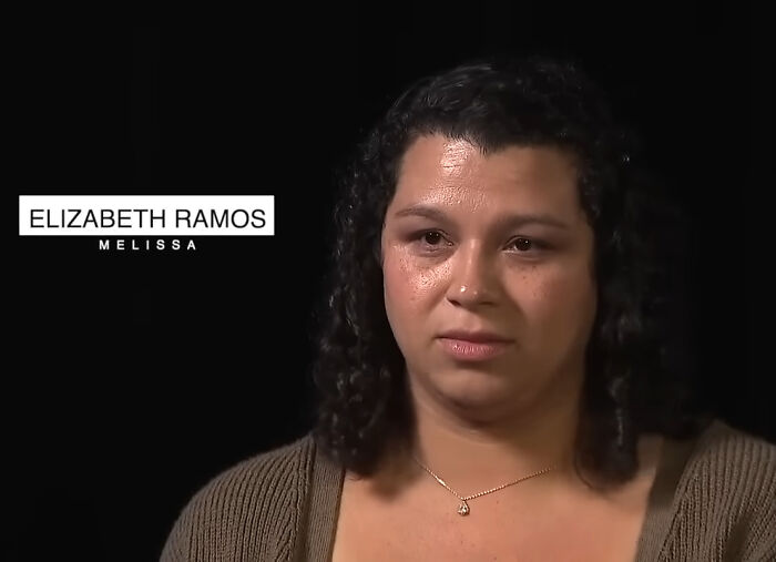 Woman with curly hair wearing a brown sweater and necklace in an interview about the miracle of sisters found alive after 36 years missing