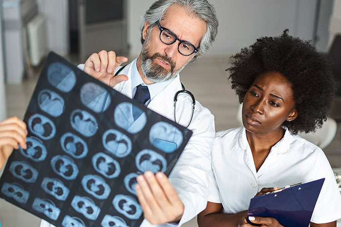 Doctor and nurse examining medical scans in a hospital setting highlighting unexpected surgery cases from small issues.