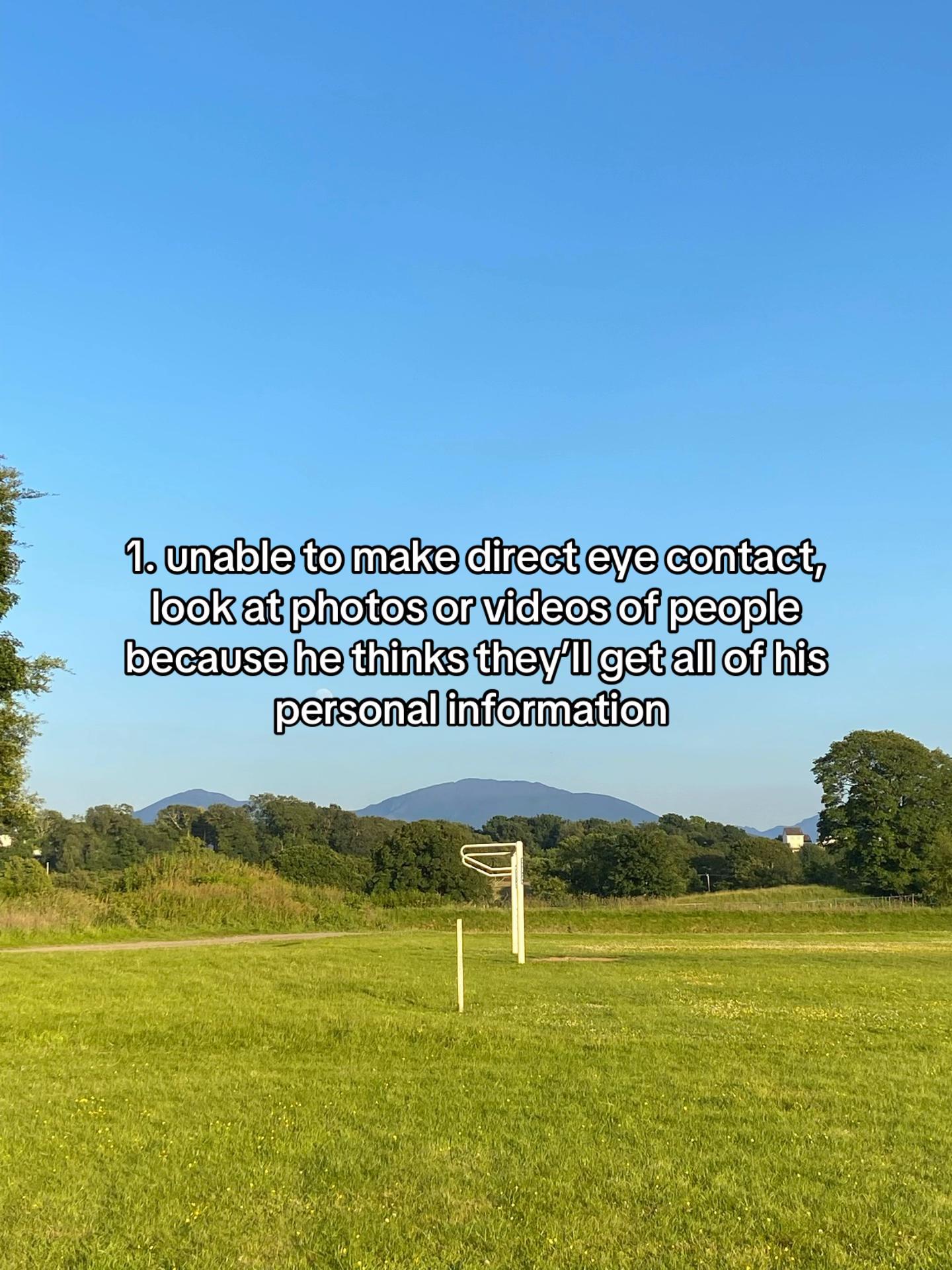 Open grassy park with a netball post and text about a boyfriend with OCD and challenges with eye contact and photos.