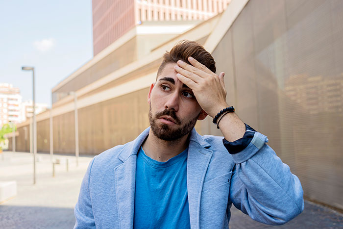 Young man with confused expression outdoors, illustrating what social cues really confuse people in everyday situations.