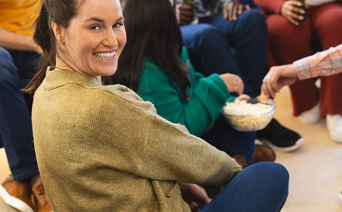 A group of people sitting together casually, sharing snacks and exhibiting social cues that confuse them.