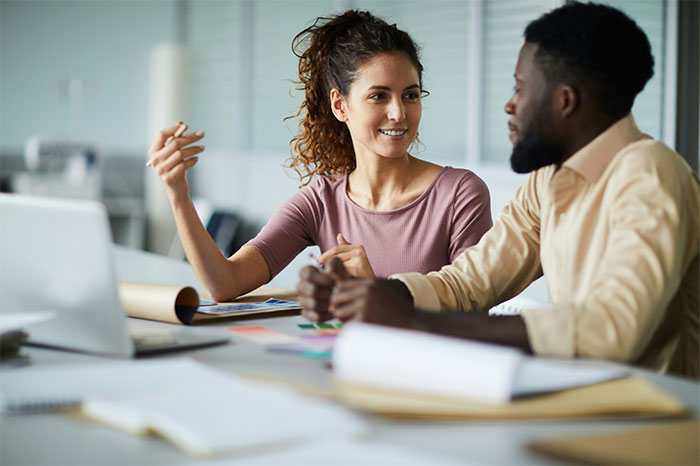 Two colleagues with high social skills engage in a conversation, avoiding common mistakes in communication.