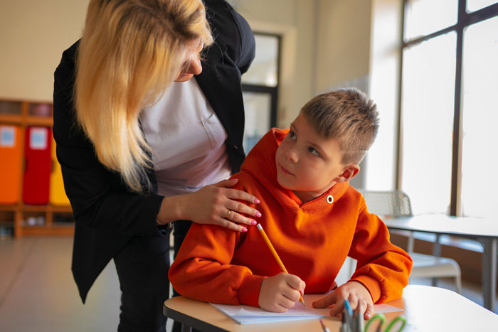 Teacher speaking to a diabetic student in orange hoodie in classroom, highlighting conflict over school health rules.