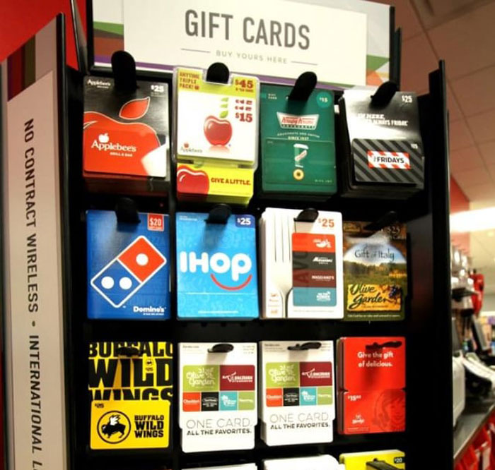 Display of various convenience store gift cards including Applebee's, Domino's, IHOP, and Buffalo Wild Wings for purchase.