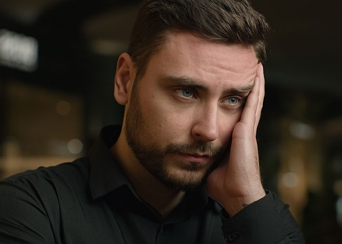 Sad step-dad holding his face, reflecting heartbreak after realizing girlfriend and her daughter don&rsquo;t care about him