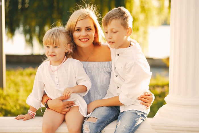Mom with her kids outdoors, showing the complex relationship involving stepmom and lasting family tensions.