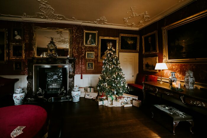 Ornate vintage living room with Christmas tree and wrapped presents, showcasing bizarre things found inside strangers' houses.