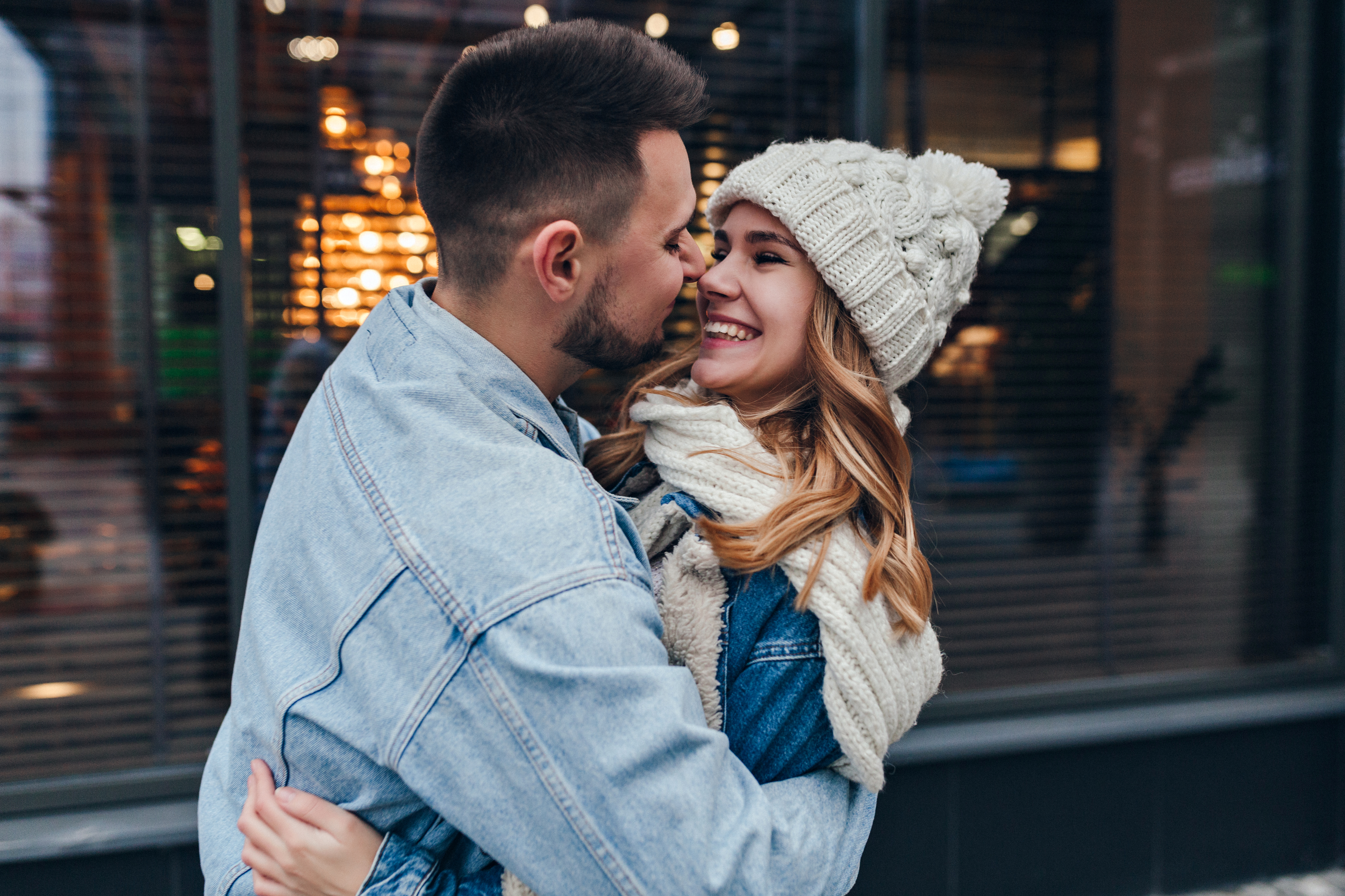 Young couple outdoors hugging closely, highlighting man begging girlfriend to resume shaving and wearing makeup routine.