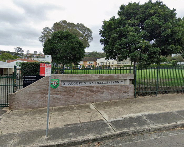 Entrance of St Augustine's College Sydney with surrounding trees and a sidewalk, related to teen shocking texts with teacher incident.