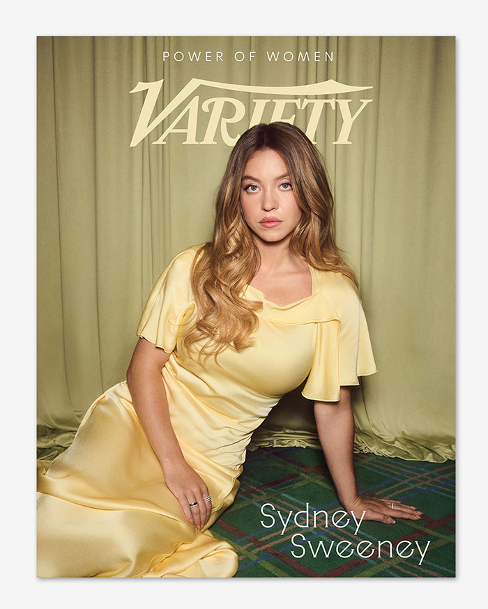 Sydney Sweeney wearing a see-through dress at Variety event, posing on the floor with wavy hair and natural makeup