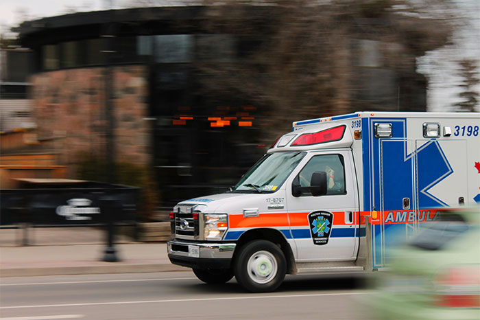 Ambulance speeding on city street, highlighting urgent medical response for symptoms that led to cancer diagnosis.