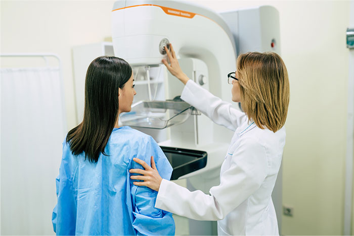 Doctor explaining cancer symptoms to patient before a mammogram breast cancer screening procedure