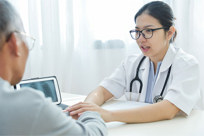 Doctor with stethoscope consulting patient about symptoms that made people see a doctor and led to cancer diagnosis.
