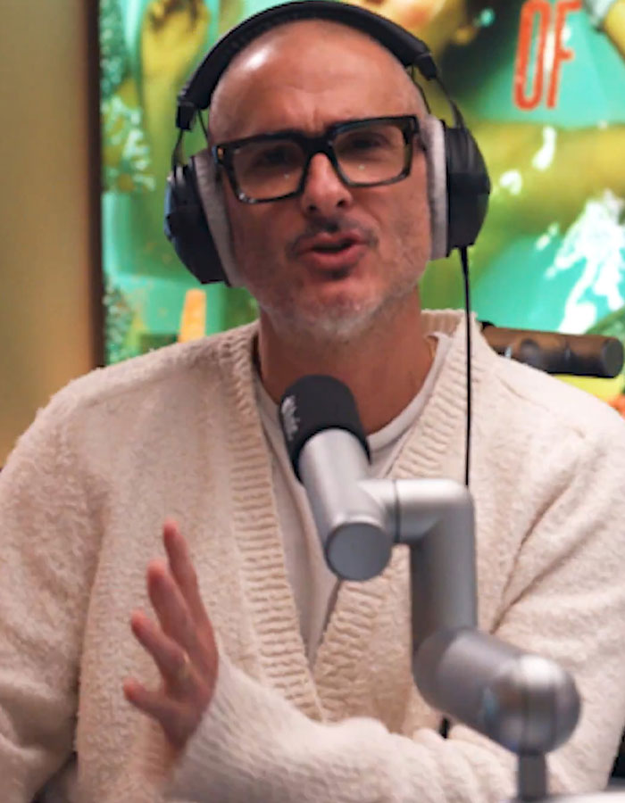Man wearing headphones and glasses speaking into a microphone during a podcast about cosmetic procedures and Taylor Swift fans. Man wearing headphones and glasses speaking into a microphone during a podcast about cosmetic procedures and Taylor Swift fans.