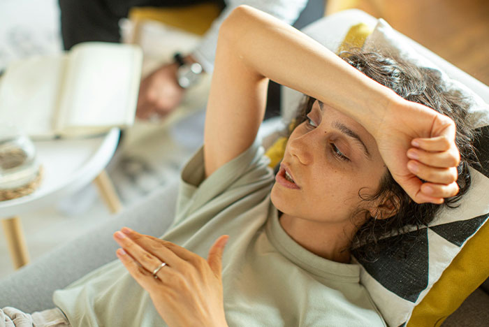 Tired woman resting on couch, showing signs of stress and frustration while dealing with caring for disabled son. Tired woman resting on couch, showing signs of stress and frustration while dealing with caring for disabled son.