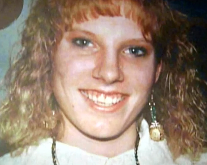Young woman with curly red hair smiling in a close-up photo related to capital punishment for jealous stabbing case.
