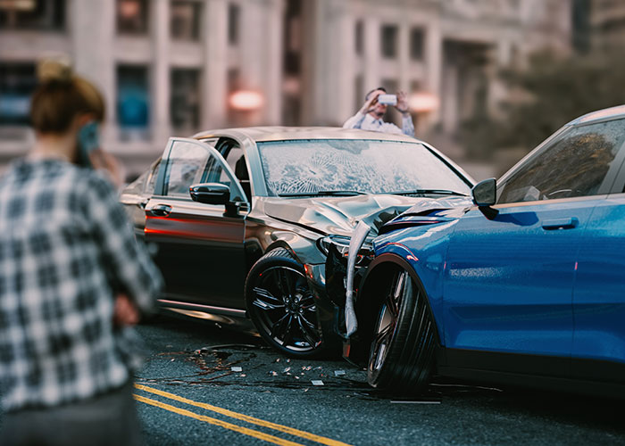 Two damaged cars after a crash with people taking photos, illustrating times people were miserable on Thanksgiving.