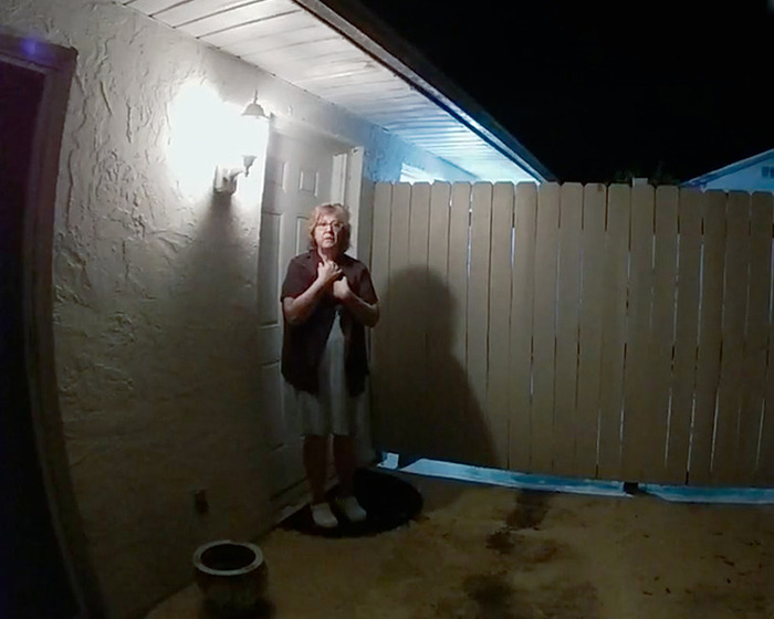 Woman standing at night outside a home in a dimly lit yard, scene related to Netflix&rsquo;s The Perfect Neighbor true story.