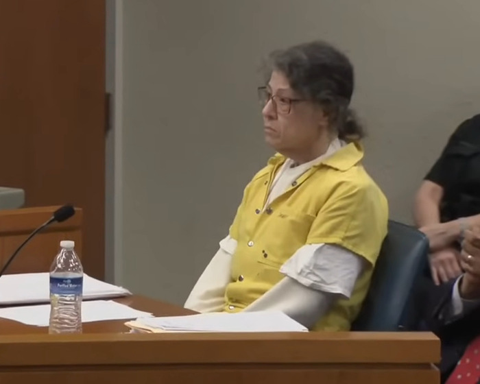 Woman in a yellow prison uniform sitting in a courtroom, related to Netflix&rsquo;s The Perfect Neighbor disturbing true story.
