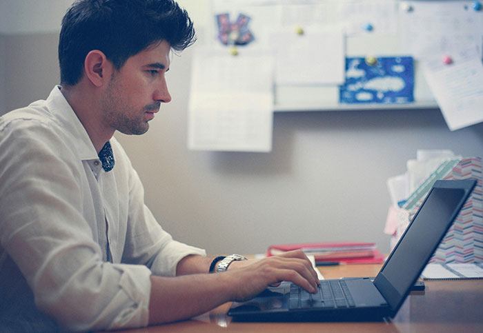 Man focused on laptop screen, realizing something unexpected, illustrating moments people aren’t supposed to see