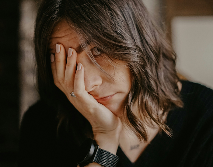 Woman looking frustrated and tired, representing the stress of being the bestie bank for a friend with multiple kids and dads.