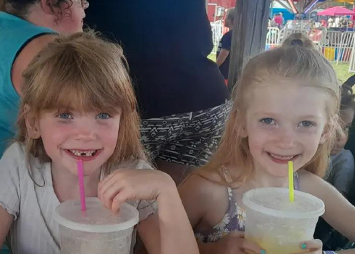 Two little sisters smiling and drinking from cups as part of a heartmelting hospital gesture for their surgery needs.
