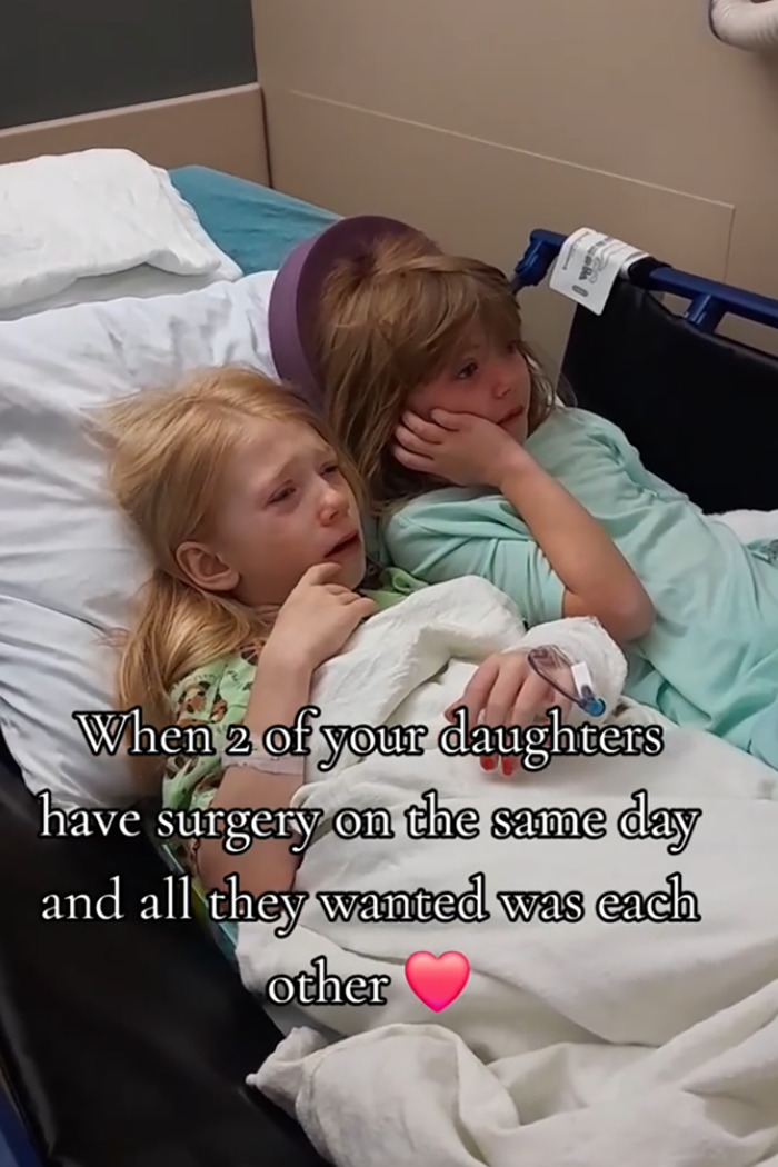 Two little sisters needing surgery lie together in a hospital bed in a heartmelting gesture that touched netizens.