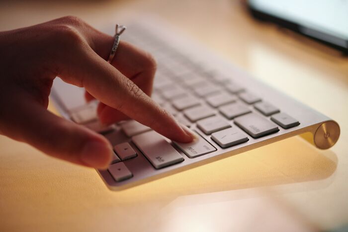 Person pressing enter key on keyboard with focus on finger, illustrating simple car stuff skills requiring minimal training.