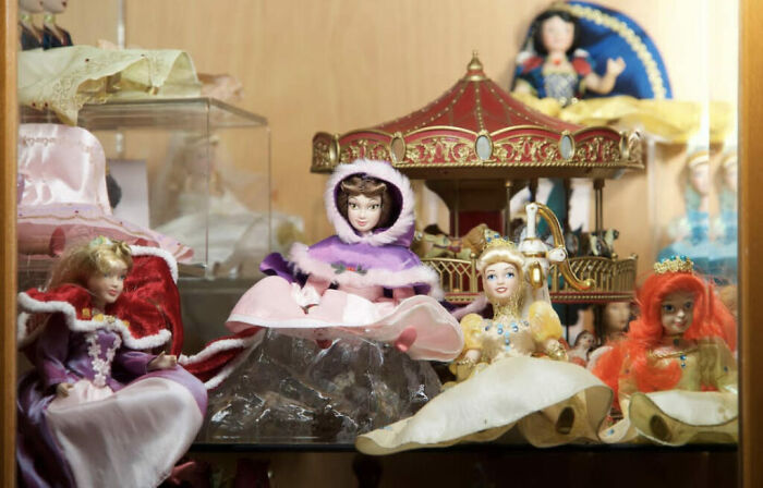 Collection of 50 dolls in a chaotic display inside a fairytale-themed Airbnb with witch-like vintage decor.