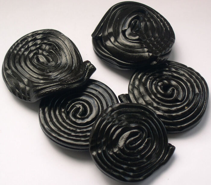Black licorice candy spirals arranged on a white background representing an unpopular opinions poll concept.