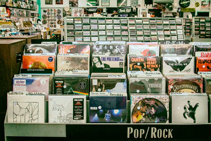 Rows of vinyl records displayed in a music store under the Pop Rock section for unpopular opinions poll 4 discussion.