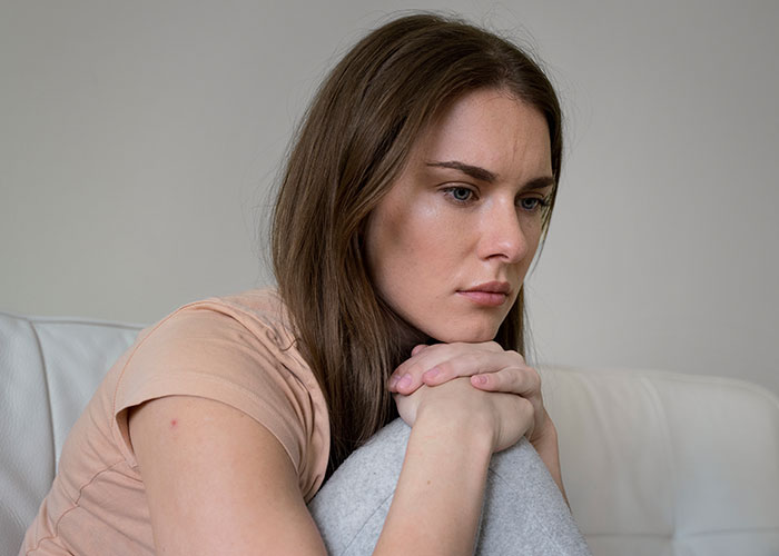 Bride looking upset and thoughtful after wedding vendors failed to provide cupcakes due to her allergy concerns.
